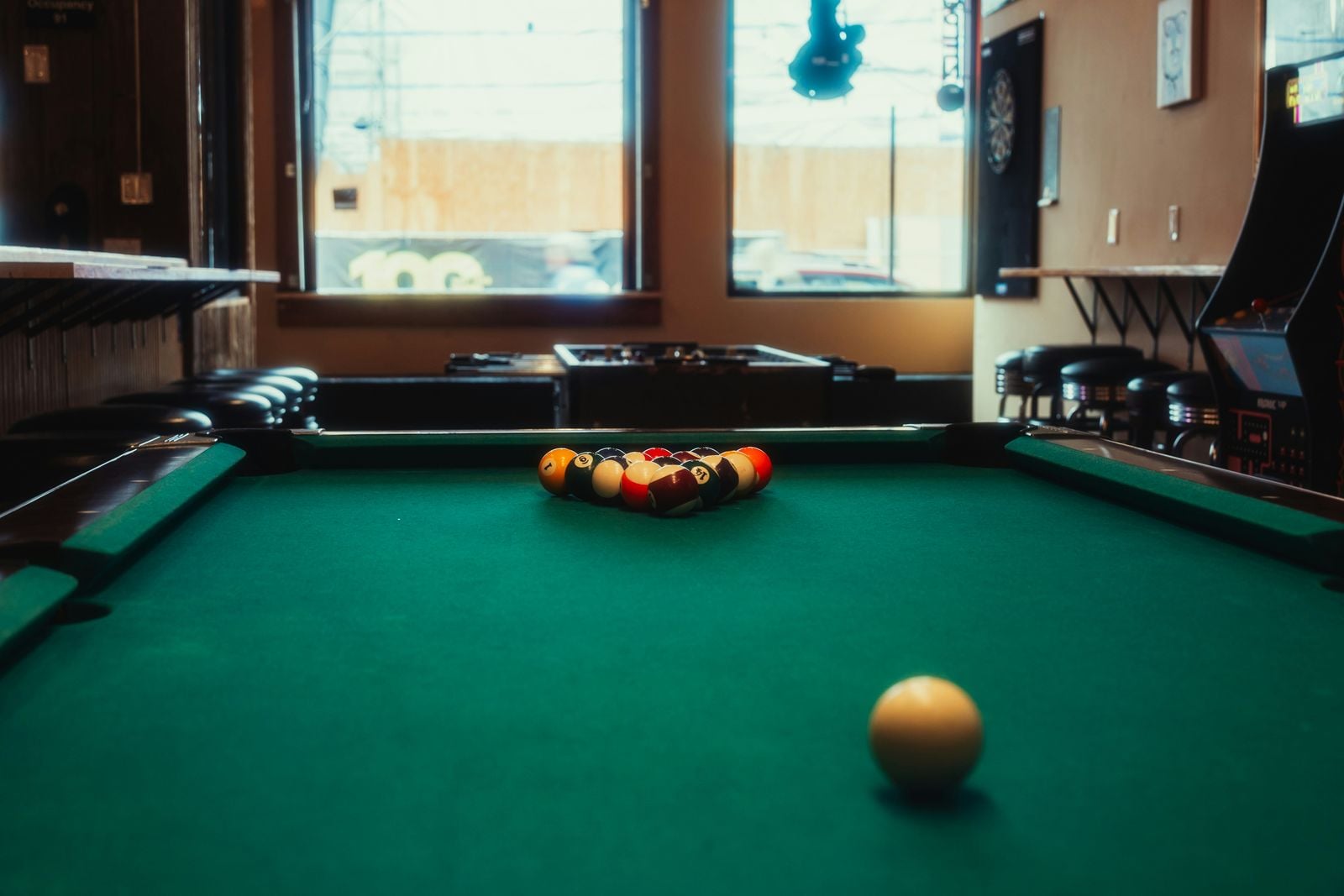 Pool table racked in a neighborhood bar.