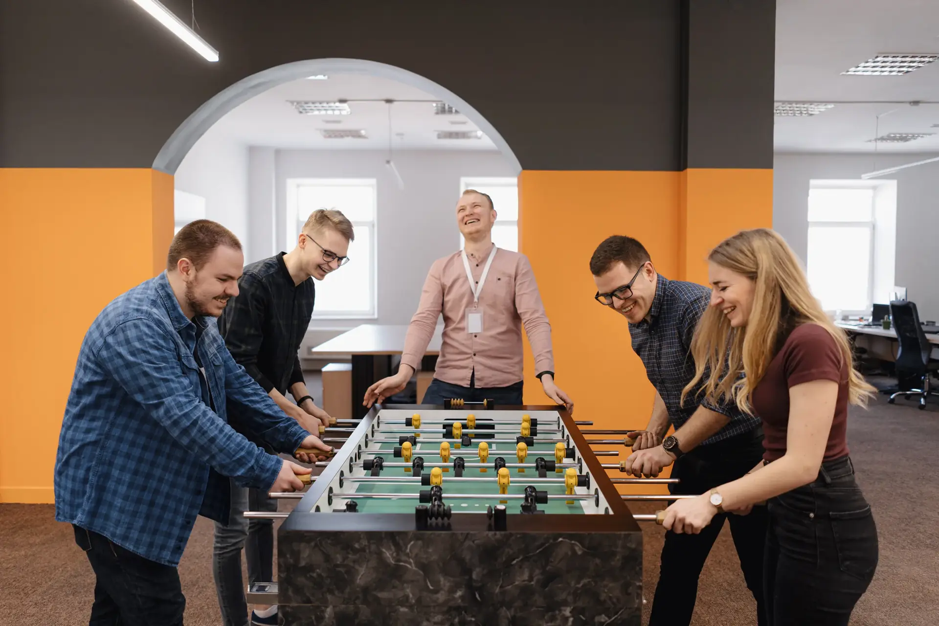 Group playing foosball